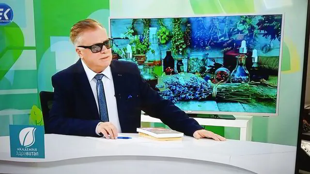 Снимка на Д-р Деянов, седнал на стол на водещия в предаването  Академия Здравитал по телевизия Евроком, в разговор със събеседник.